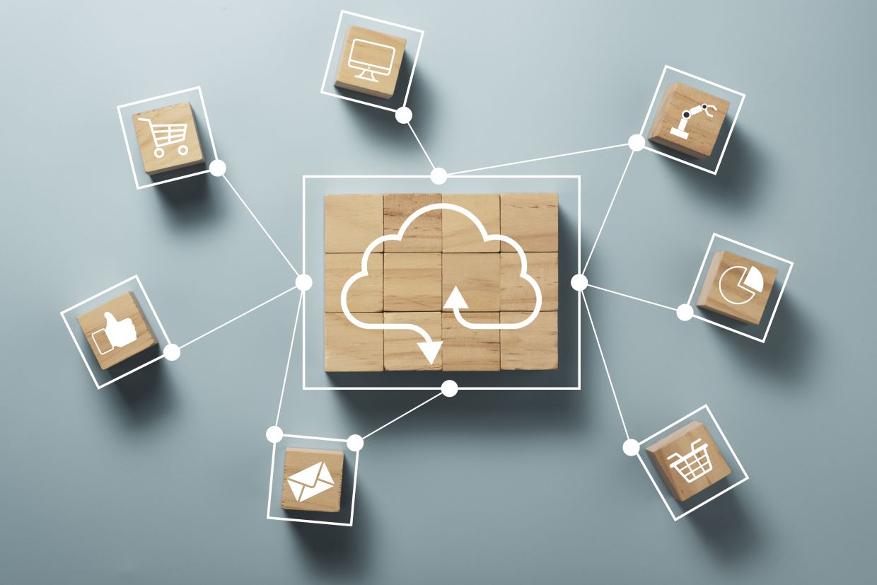 Duas mãos de uma pessoa de pele clara, mexendo em um notekook, e por cima do notebook, algumas computações artificiais.